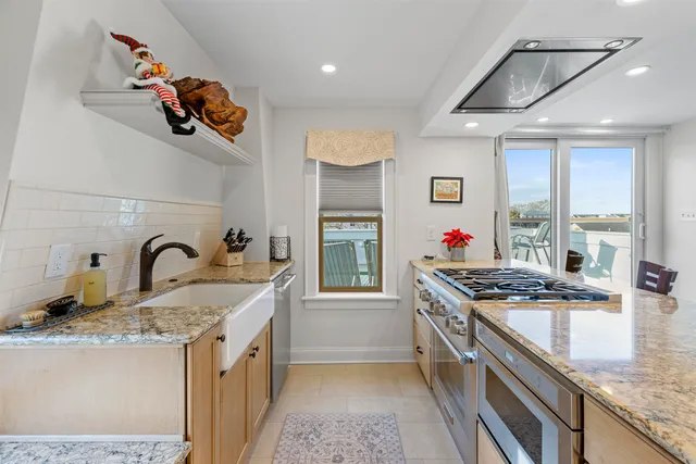 a kitchen with stainless steel appliances granite countertop a stove a sink and a refrigerator