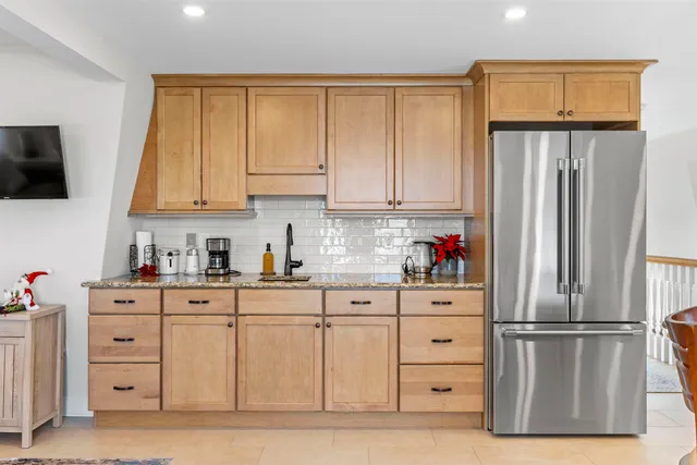 a kitchen with white cabinets and refrigerator