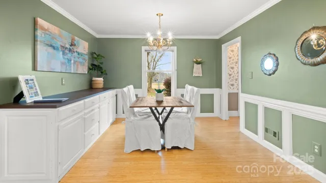 a view of a dining room with furniture a chandelier and wooden floor