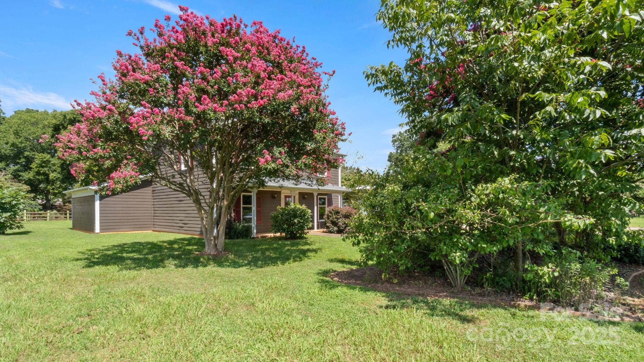 8809 Fairview Road Mint Hill, NC 28227 - Photo 35 of 43 a front view of a house with a tree and garden