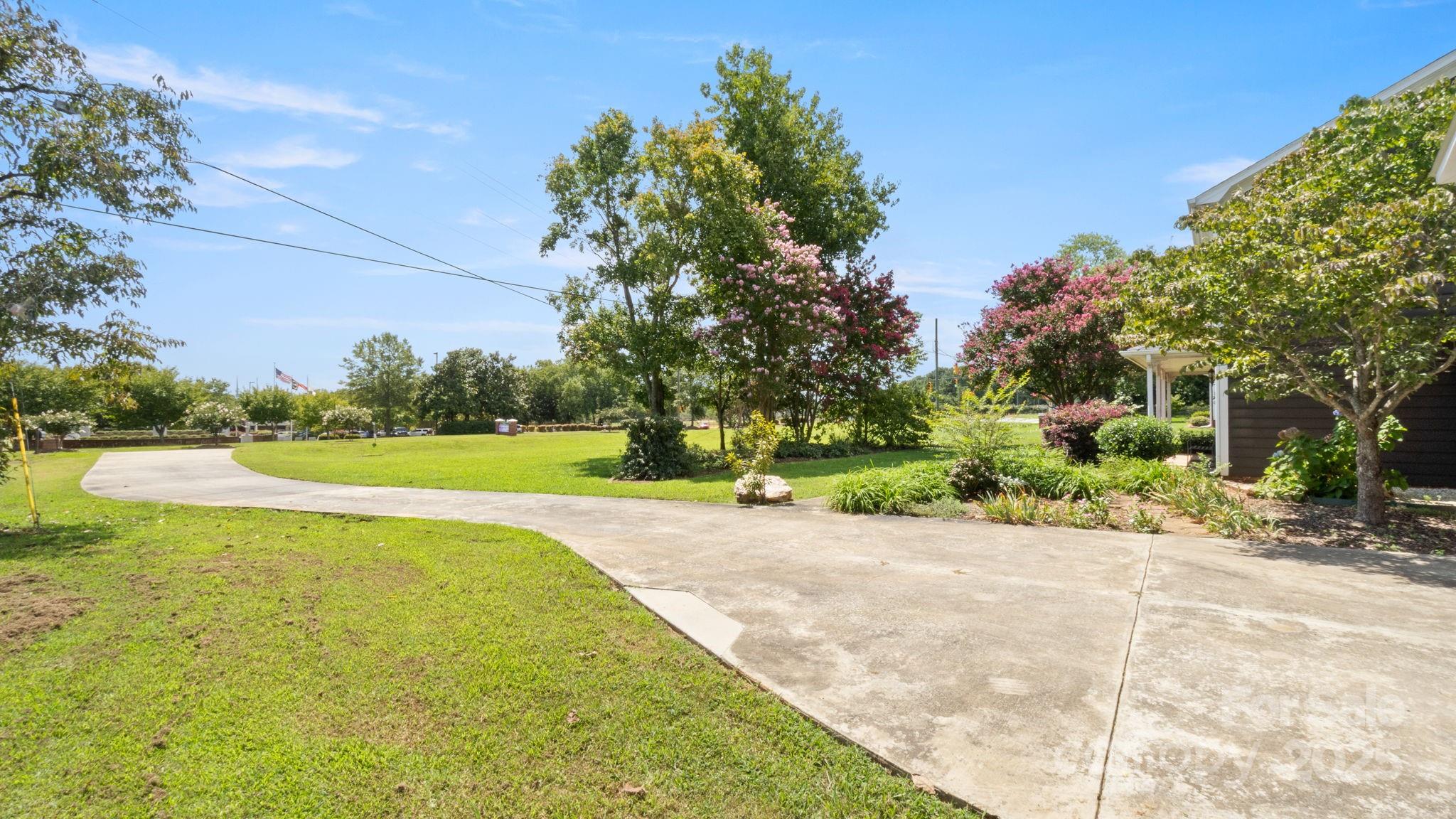 8809 Fairview Road Mint Hill, NC 28227 - Photo 39 of 43 a view of a garden with a bench