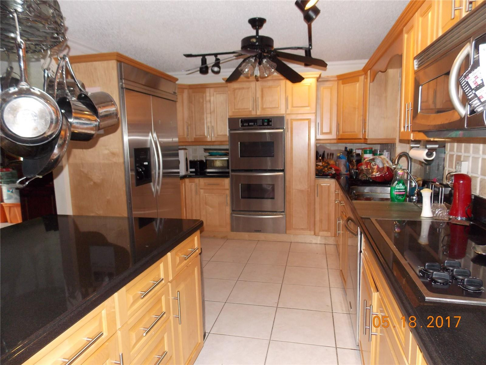 18521 Southwest 55th Street Southwest Ranches, FL 33332 - Photo 4 of 17 a kitchen with stainless steel appliances granite countertop a sink a stove and a refrigerator