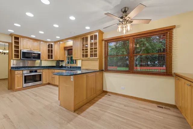 a kitchen with stainless steel appliances granite countertop a stove top oven a sink and a refrigerator