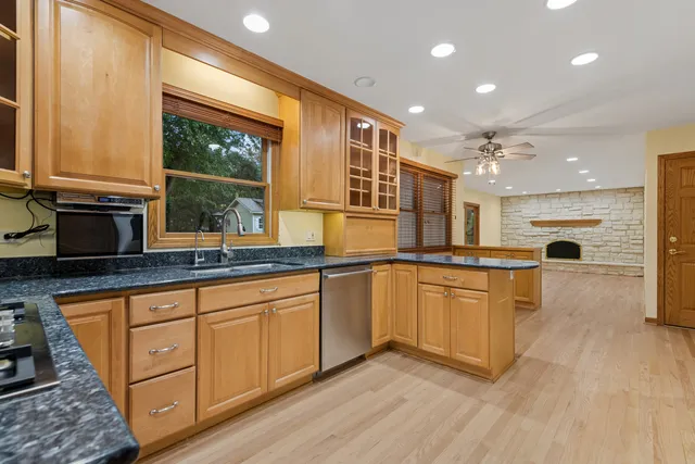a kitchen with granite countertop a stove a sink and a refrigerator