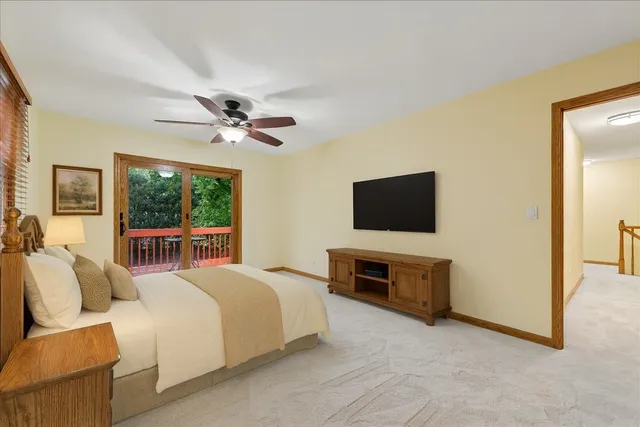 a bedroom with furniture a flat screen tv and a ceiling fan