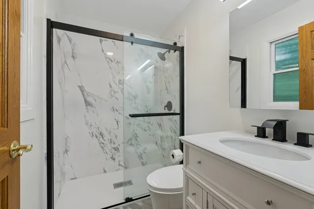 a bathroom with a granite countertop sink toilet and shower