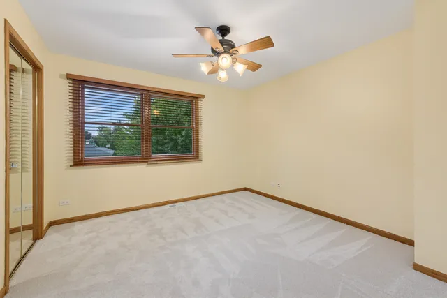 an empty room with window and ceiling fan
