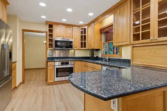 a kitchen with stainless steel appliances granite countertop a stove a sink and a refrigerator