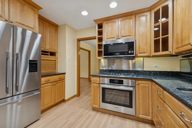 a kitchen with stainless steel appliances granite countertop a stove microwave and refrigerator