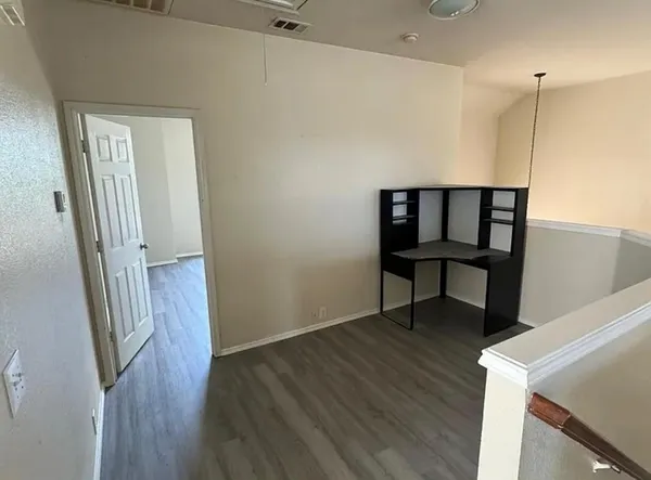 a view of a hallway with wooden floor and furniture