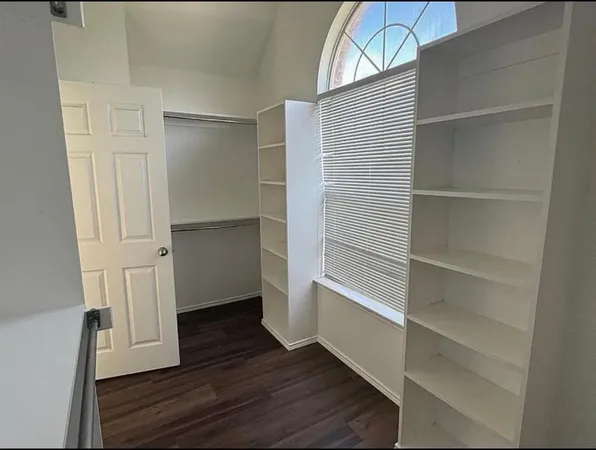 a view of walk in closet with empty racks