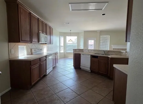 a kitchen with stainless steel appliances granite countertop a sink counter space cabinets and a large window