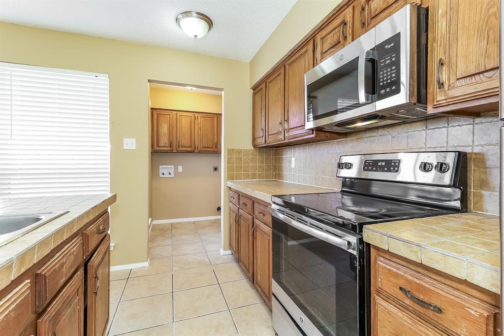 857 Via Altos Mesquite, TX 75150 - Photo 5 of 16 a kitchen with stainless steel appliances granite countertop a stove and a microwave
