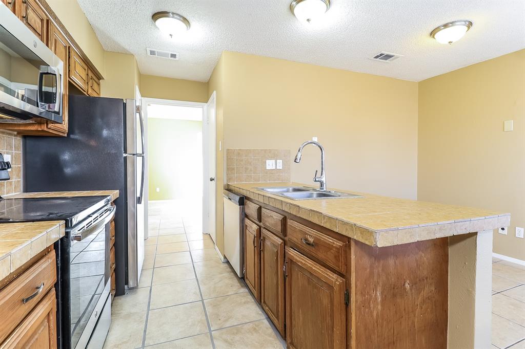 857 Via Altos Mesquite, TX 75150 - Photo 6 of 16 a kitchen with stainless steel appliances a sink and a refrigerator