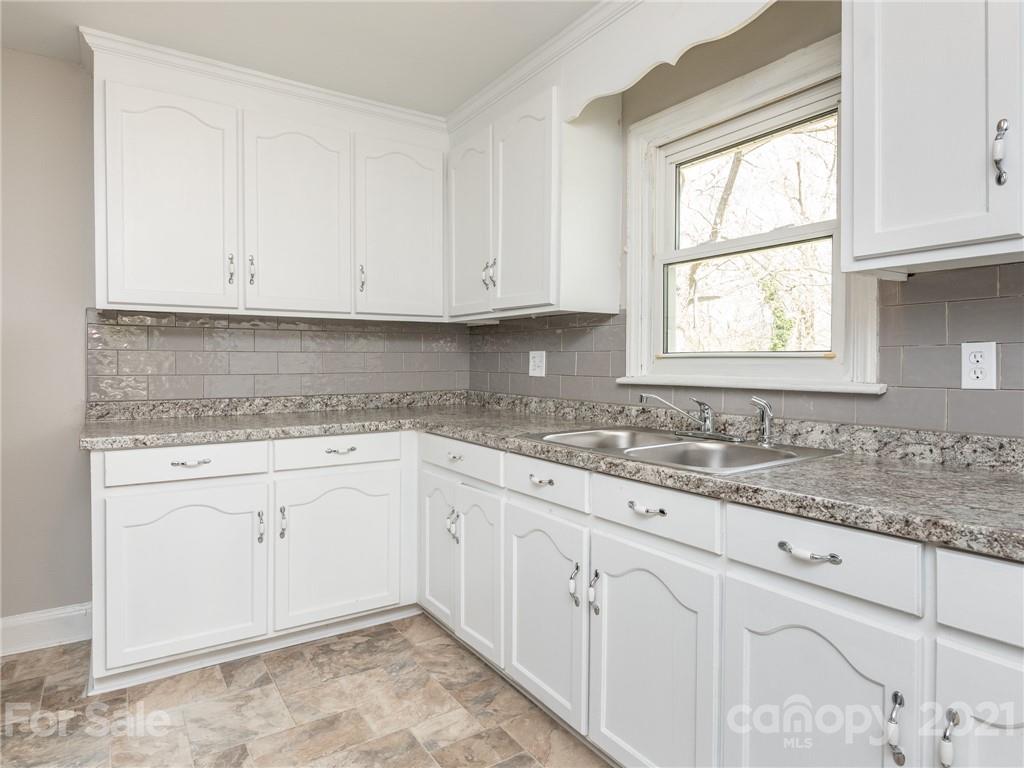 502 Davis Park Road Gastonia, NC 28052 - Photo 2 of 20 a kitchen with granite countertop white cabinets sink and window