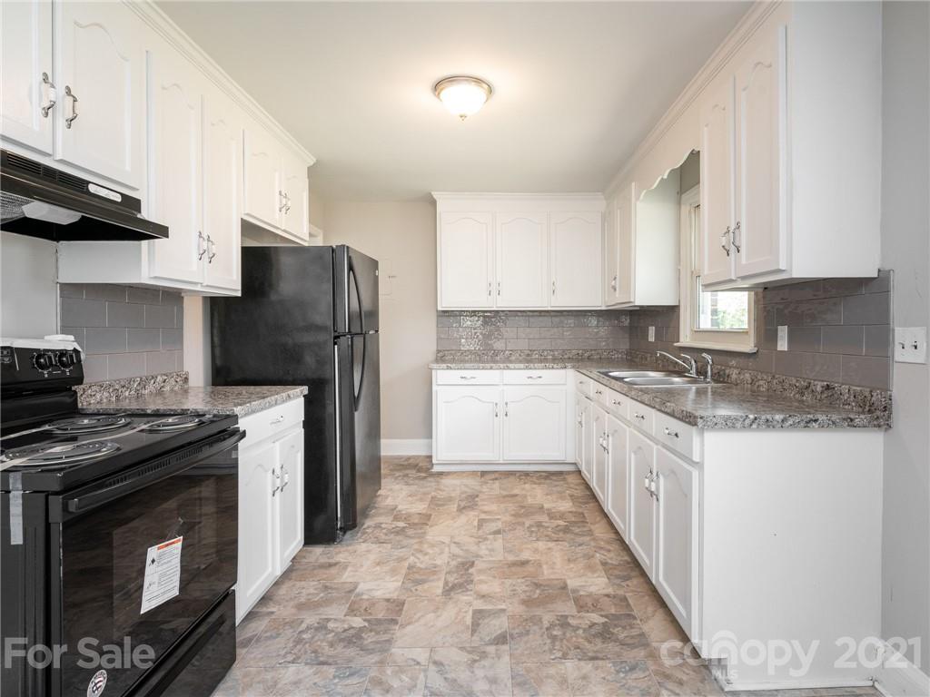 502 Davis Park Road Gastonia, NC 28052 - Photo 4 of 20 a kitchen with granite countertop a stove top oven sink and cabinets