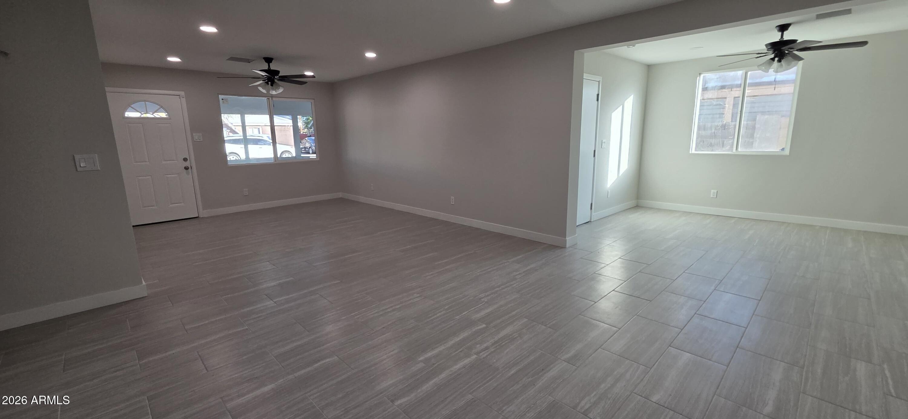 5721 West Cheery Lynn Road Phoenix, AZ 85031 - Photo 7 of 20 a view of an empty room with a window and wooden floor