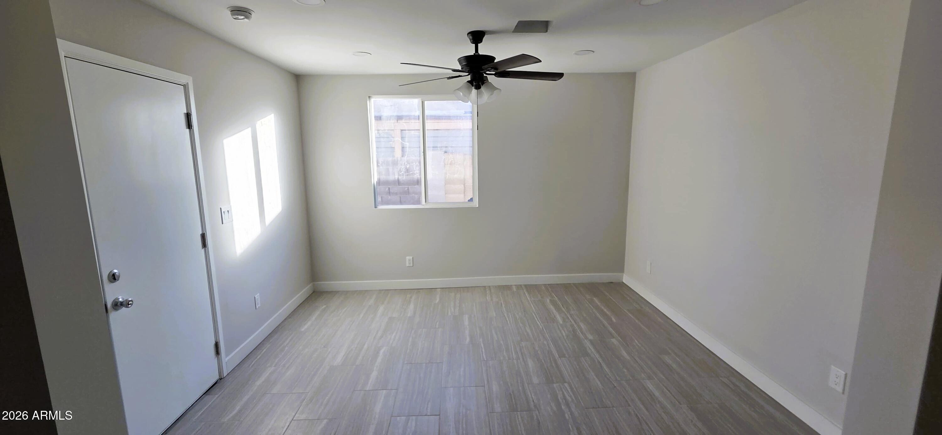 5721 West Cheery Lynn Road Phoenix, AZ 85031 - Photo 9 of 20 wooden floor in an empty room with a window