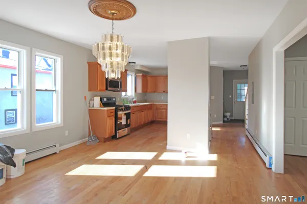 a living room with kitchen island granite countertop furniture and a chandelier