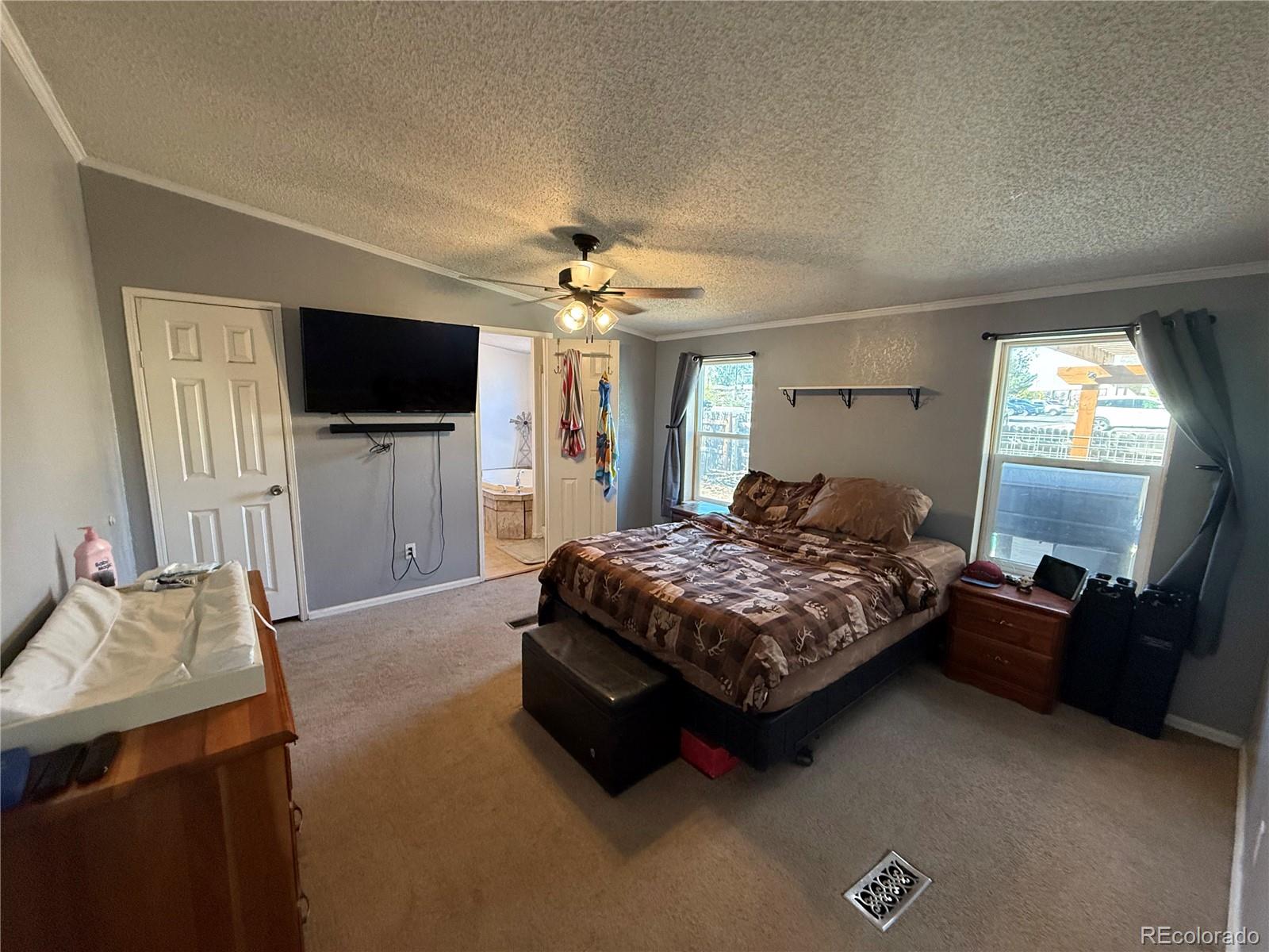 3439 West 3rd Street Road Greeley, CO 80631 - Photo 14 of 31 a bedroom with a bed and a flat screen television