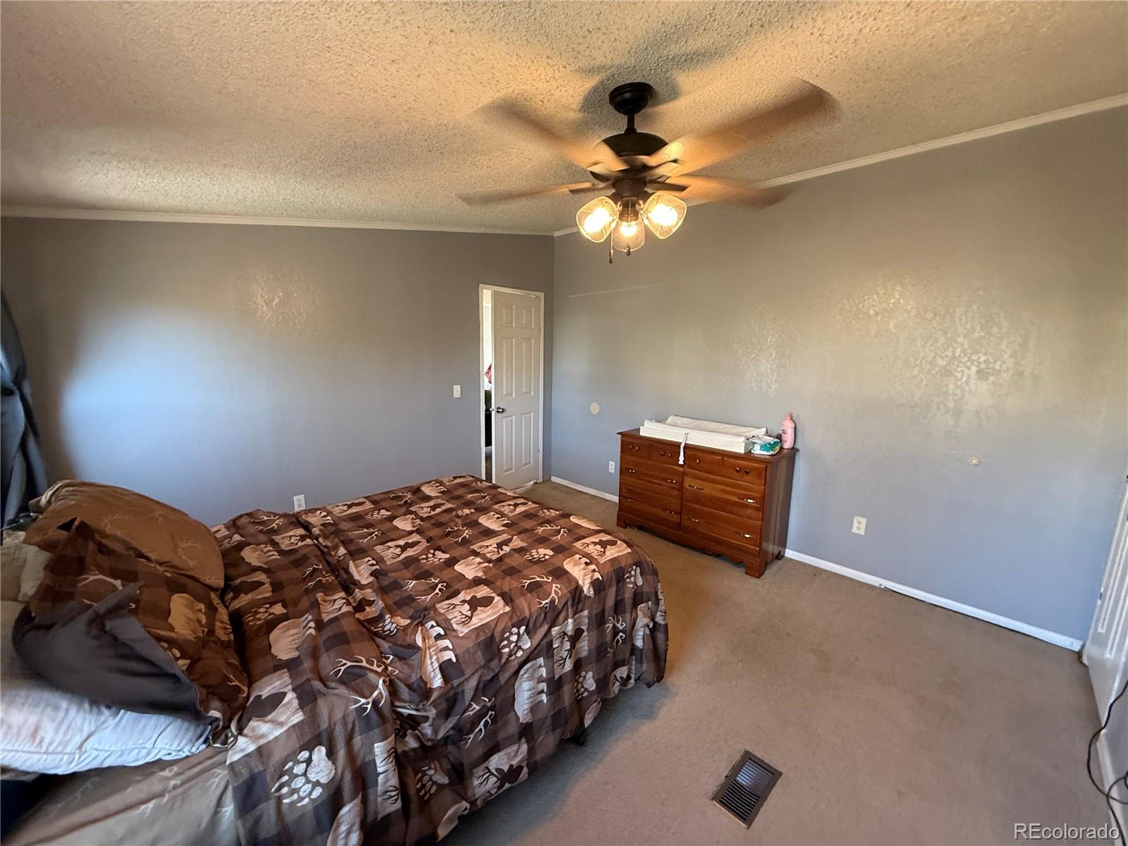3439 West 3rd Street Road Greeley, CO 80631 - Photo 15 of 31 a bedroom with a bed and a ceiling fan
