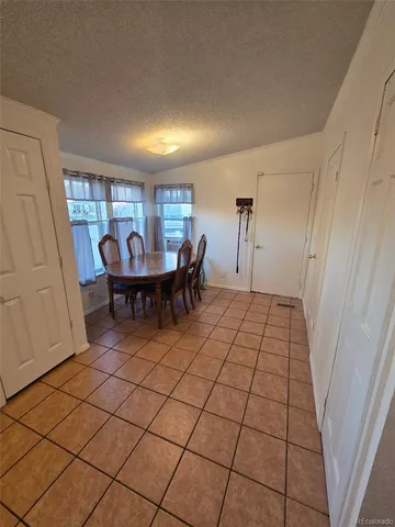 a kitchen with granite countertop a stove a sink a dining table and chairs