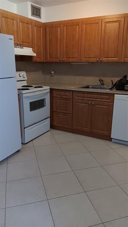 4169 Southwest 67th Avenue, Unit 209A Davie, FL 33314 - Photo 7 of 18 a kitchen with stainless steel appliances granite countertop a stove a sink and a refrigerator