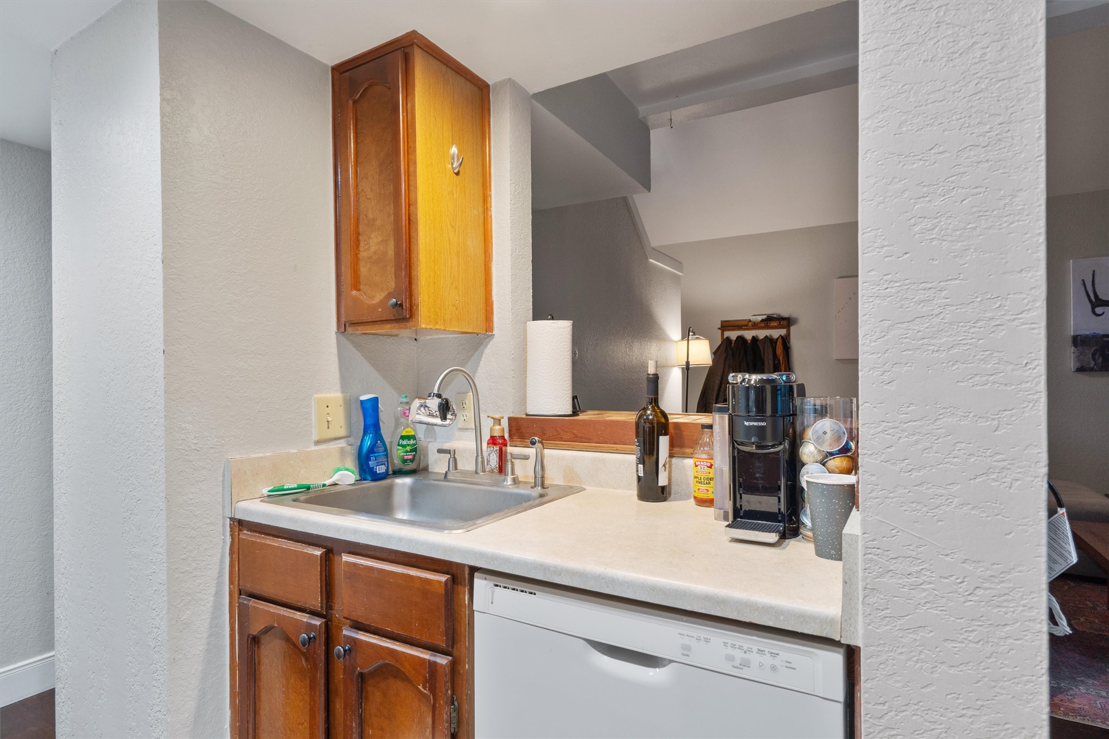 2414 Jones Road Austin, TX 78745 - Photo 10 of 26 A compact and functional kitchen space includes a stainless steel sink and essential appliances for everyday convenience.