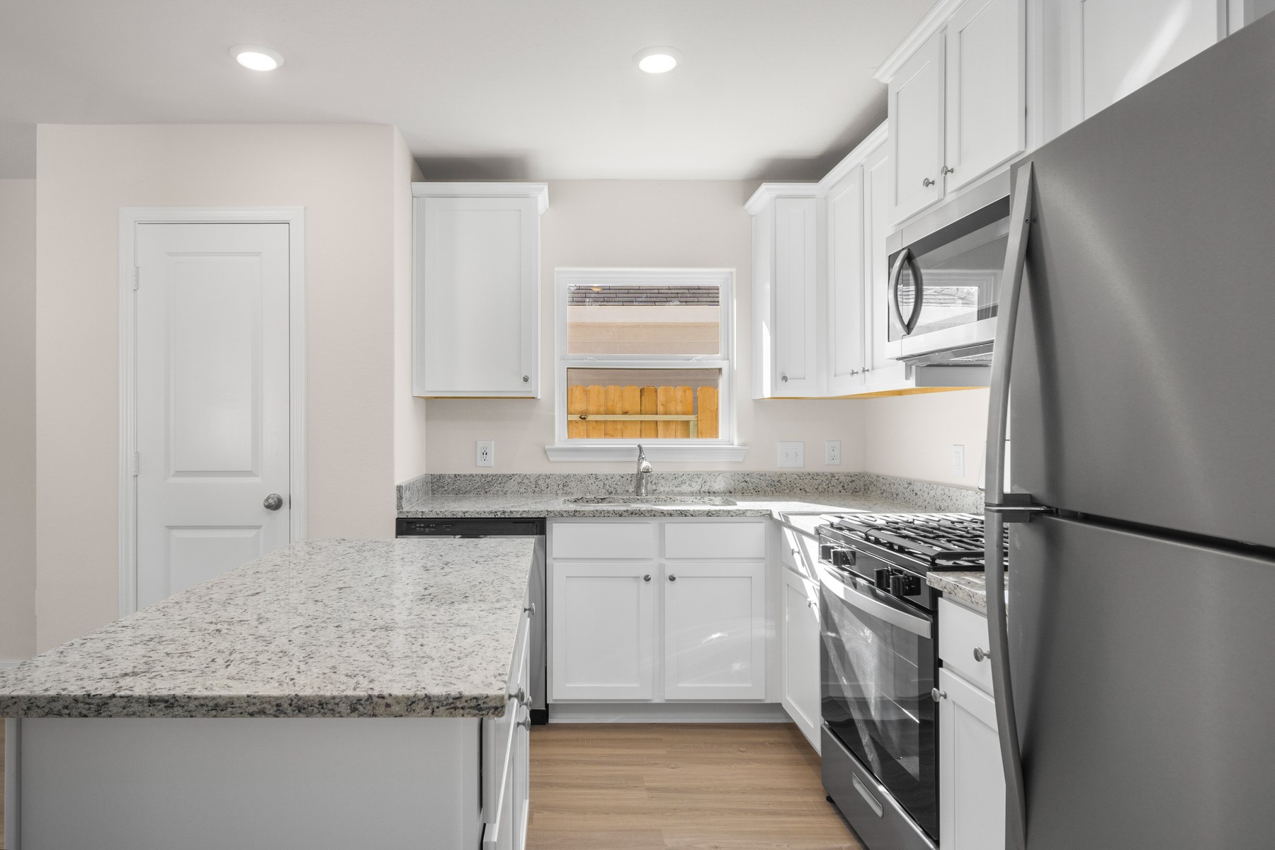 345 Fastboy Lane Waller, TX 77484 - Photo 2 of 21 a kitchen with granite countertop a sink stove and refrigerator