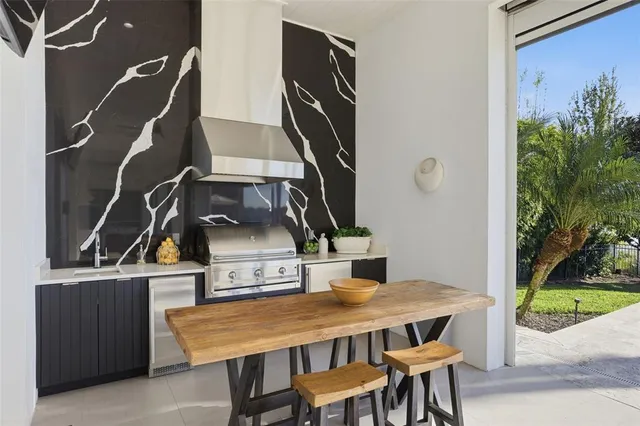 a living room with furniture large windows and wooden floor