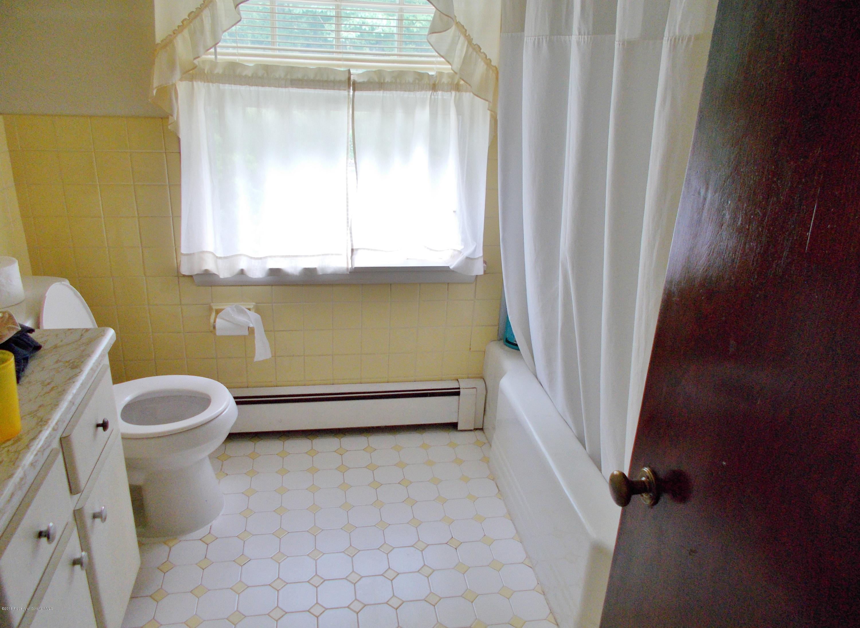 577 Pa-rt690 Road Moscow, PA 18444 - Photo 7 of 16 a bathroom with a toilet a sink and a window