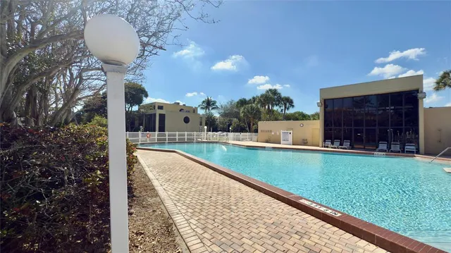 a view of a swimming pool with a patio and a yard