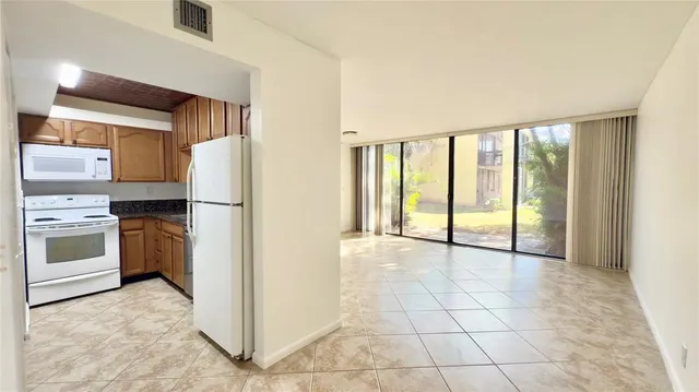 a view of a kitchen with a stove cabinets and front door