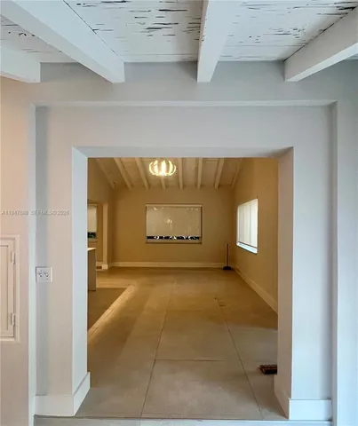 a view of a hallway with wooden floor and a window