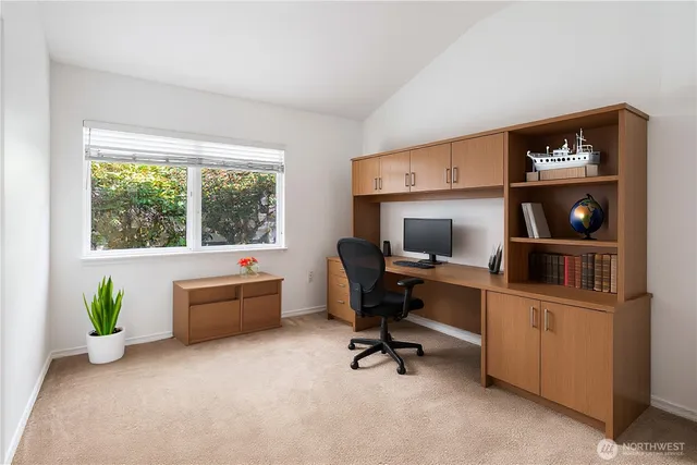 a view of a workspace with furniture and a window
