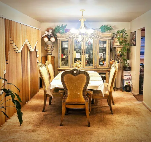 a dining room with furniture a chandelier and wooden floor