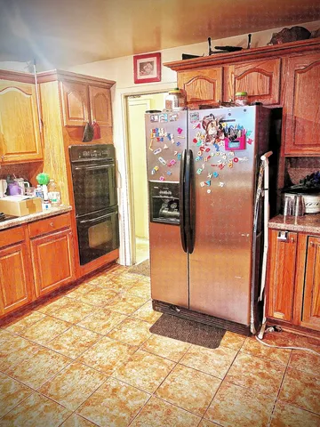 a kitchen with refrigerator and cabinets