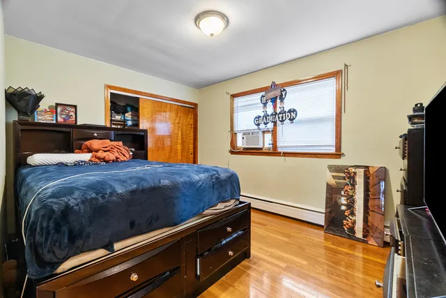 a bedroom with a bed and a flat tv screen on dresser