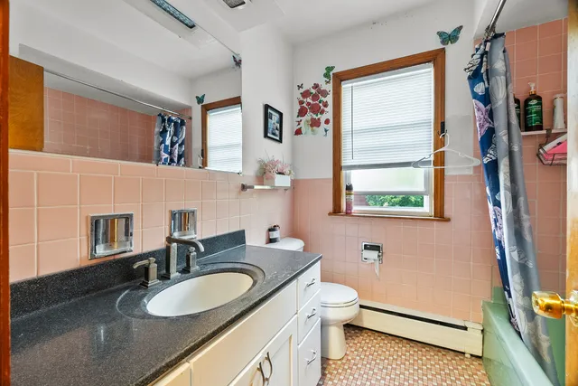 a bathroom with a granite countertop sink mirror vanity and a toilet