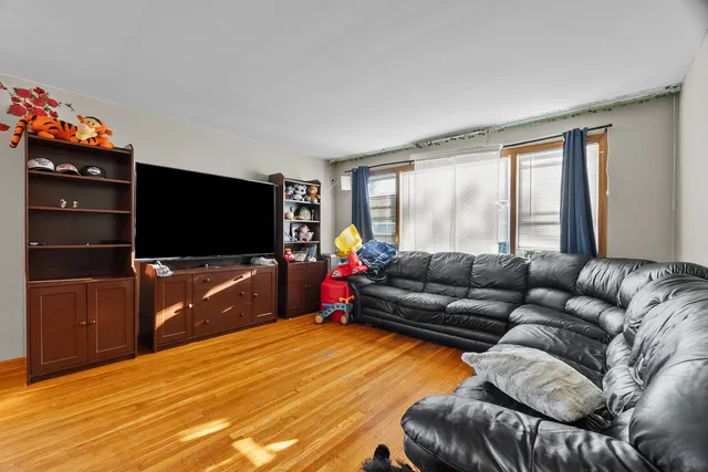 a living room with furniture a flat screen tv and a floor to ceiling window