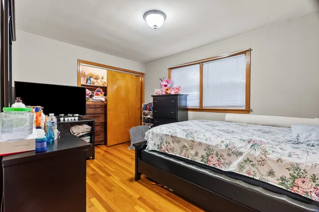 a bedroom with a bed and a flat tv screen on dresser