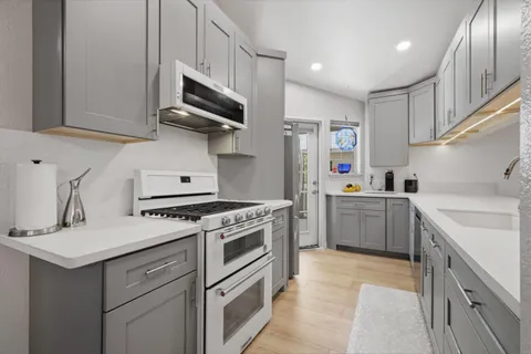 a kitchen with a stove sink and cabinets