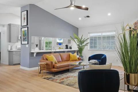 a living room with furniture potted plant and a large window