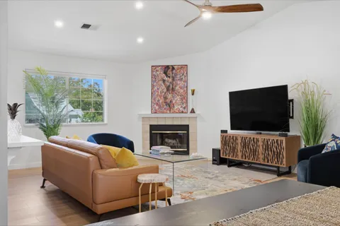 a living room with furniture a flat screen tv and a fireplace
