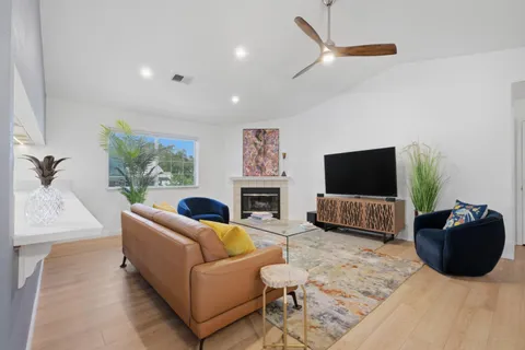 a living room with furniture a flat screen tv and a large window