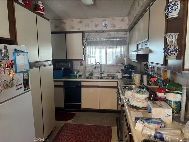 a kitchen with a refrigerator and a stove top oven