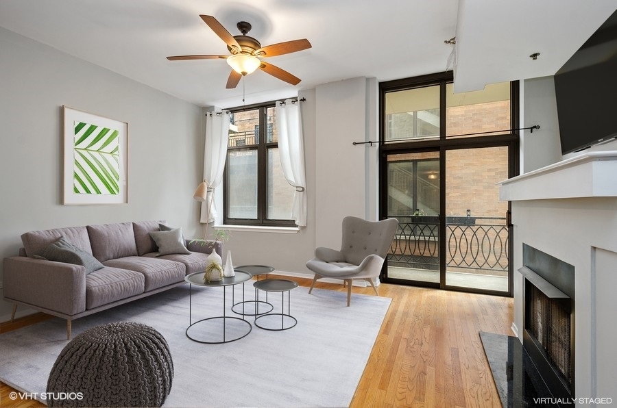 1201 West Adams Street, Unit 609 Chicago, IL 60607 - Photo 2 of 13 a living room with furniture a fireplace and a large window