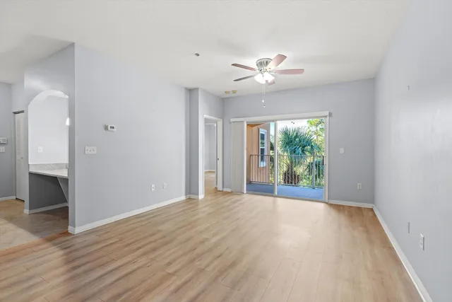 a view of an empty room with a window and wooden floor