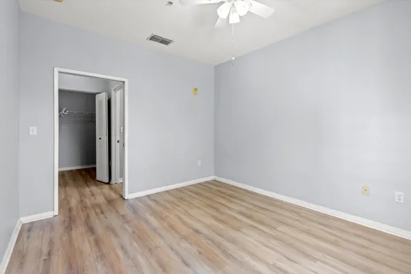a view of an empty room with wooden floor