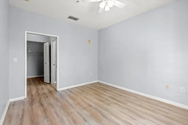 a view of an empty room with wooden floor